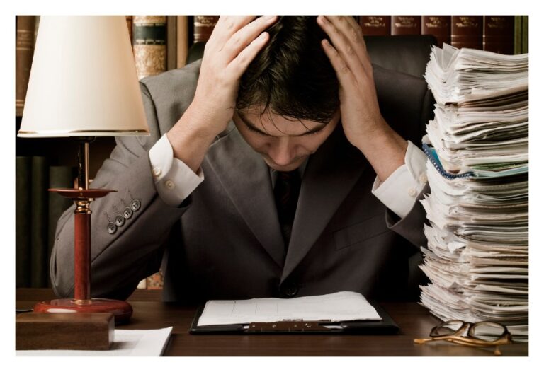 Business professional reviewing legal documents before contacting outside counsel